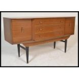 A vintage retro 1950's teak wood veneer sideboard credenza having a central bank of three drawers