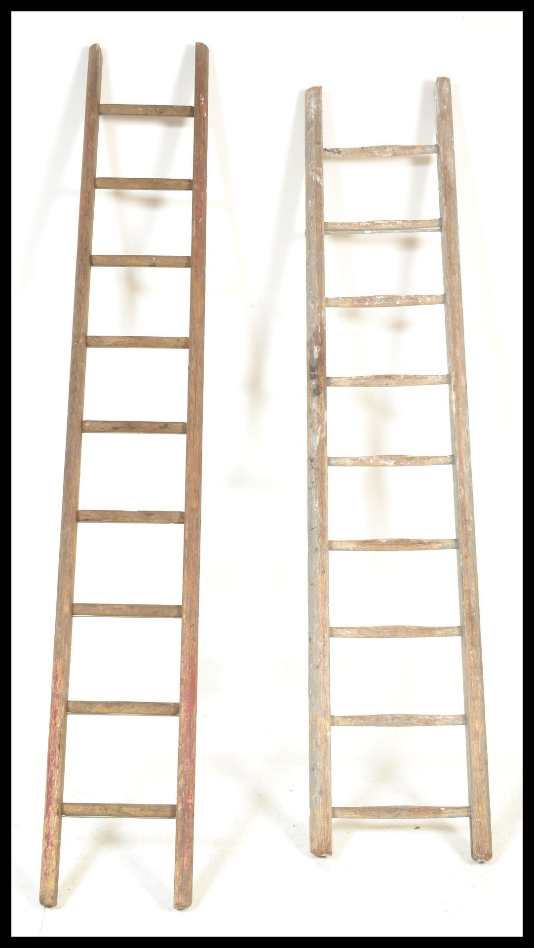 A pair of vintage mid 20th Century industrial wooden ladders, the ladders with turned steps each