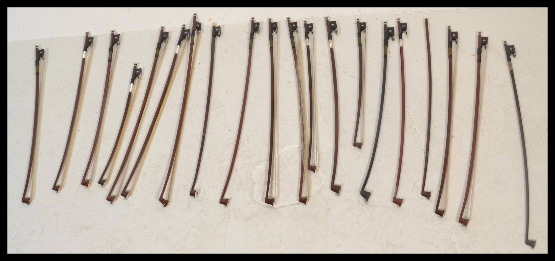 A collection of 20th Century violin bows, most bows being brazilwood and Pernambuco with ebony,