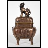 A Chinese bronze censer ding incense burner raised on four splayed feet, the base cast in relief