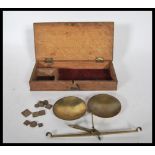 A set of vintage postage scales set within a wooden case along with a selection of brass weights