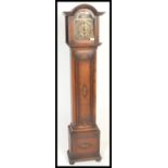 An early 20th century grandmother clock having oak case and windup movement with brass face