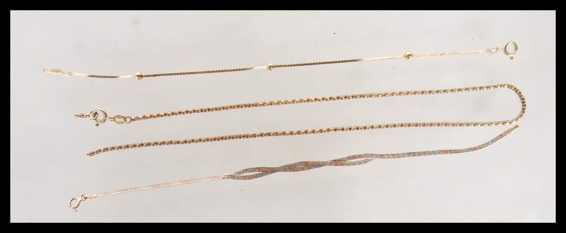 A selection of three 9ct gold jewellery items to include, a snake chain necklace having spring clasp