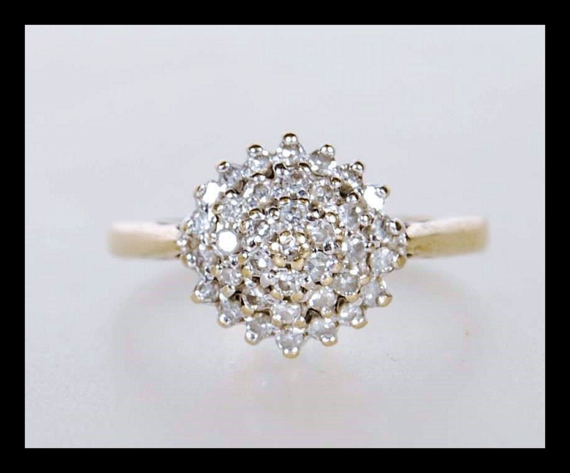 A hallmarked 9ct gold cluster ring set with white stones. Hallmarked Birmingham. Weight 2.0g. Size