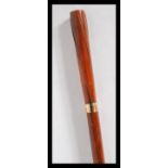 A 20th Century walking stick cane of tapering form, having gold coloured bands on a bamboo shaft,