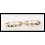 Two stamped 375 9ct gold rings having channel set round cut stones, one having blue and white