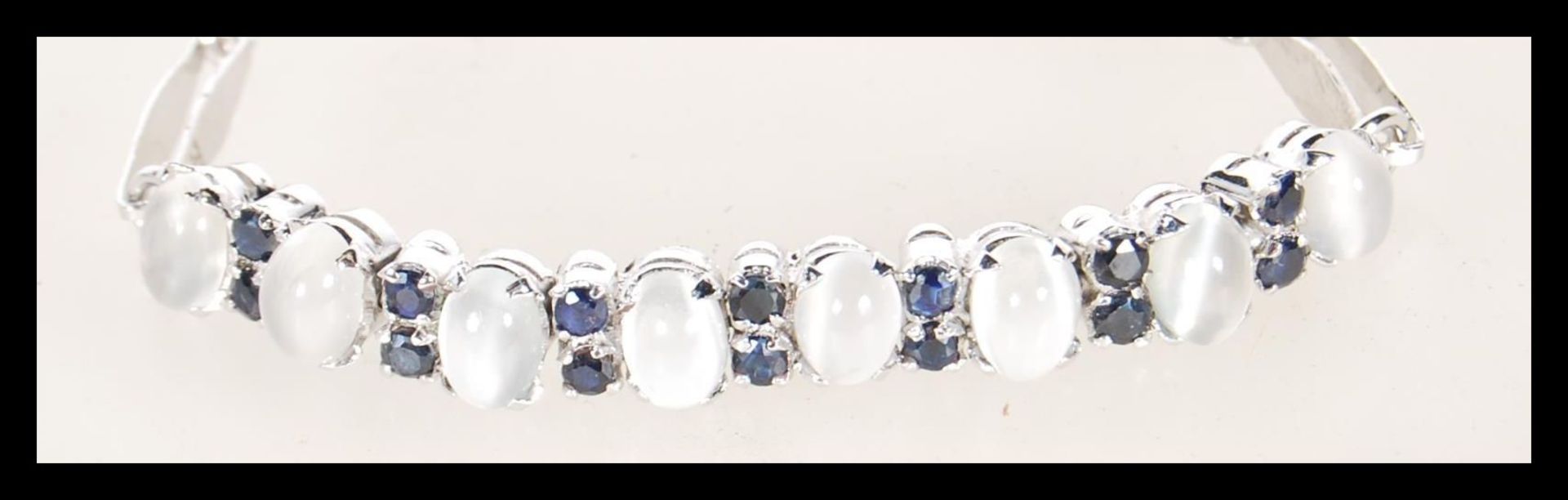 A silver 925 hallmarked chain link bracelet having a toggle clasp, the chain decorated with blue