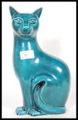 A Poole studio pottery ceramic figurine modelled as a seated cat with a turquoise glaze. Stamped