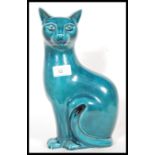 A Poole studio pottery ceramic figurine modelled as a seated cat with a turquoise glaze. Stamped