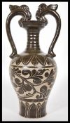 A Chinese stoneware vase / urn having shaped twin handles with floral relief decoration to the