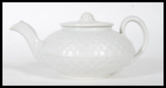 An 19th century Wedgwood caneware teapot having basket weave moulding, the flat lid with