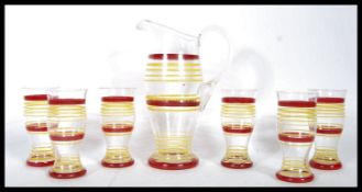 A retro mid 20th Century glass lemonade set having red and yellow striped decoration comprising of