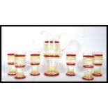 A retro mid 20th Century glass lemonade set having red and yellow striped decoration comprising of