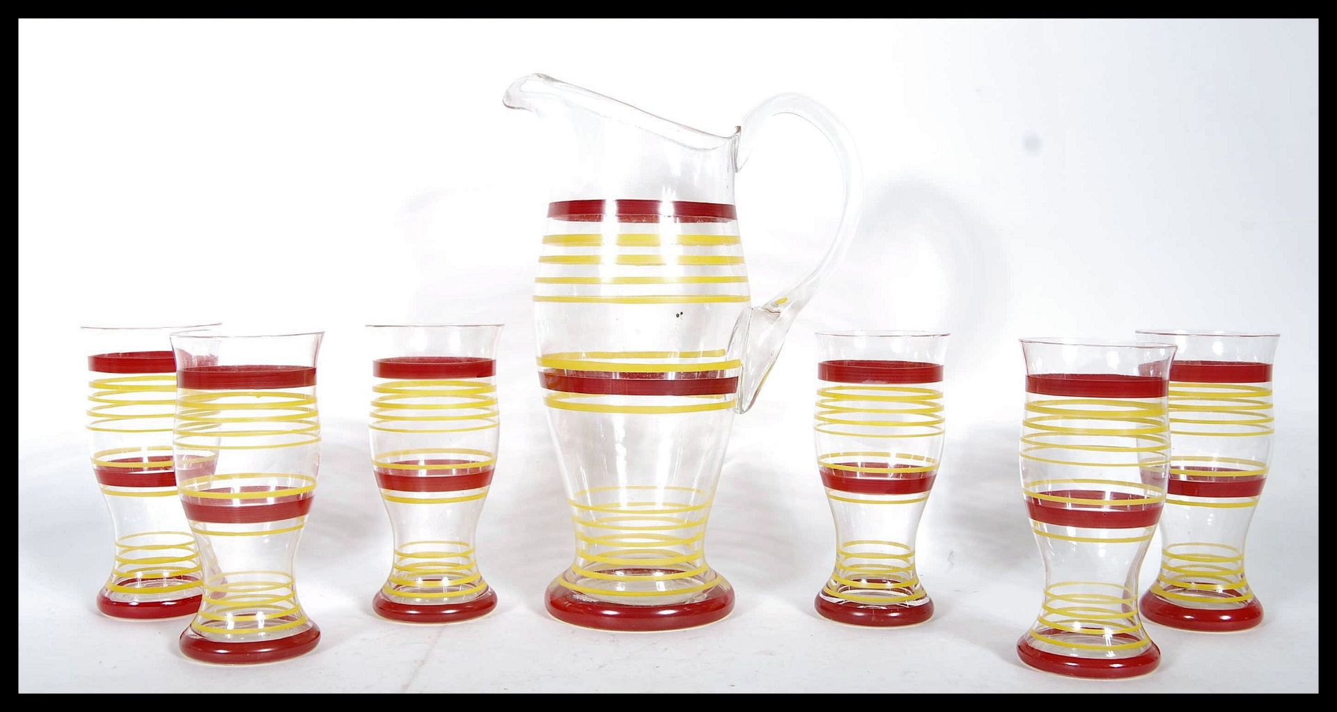 A retro mid 20th Century glass lemonade set having red and yellow striped decoration comprising of