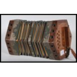 A vintage early 20th Century squeeze box of hexagonal form having pierced wood handles at each end