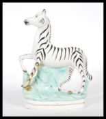 A 19th Century Victorian Staffordshire flatback figure of a zebra raised on a naturalistic plinth