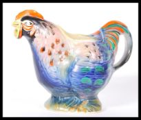 A early 20th Century 1920's novelty teapot in the form a rooster having bright coloured feathers.