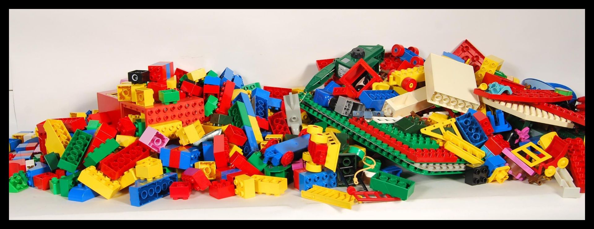 A collection of retro Duplo lego style building lots together with building pads and figures.