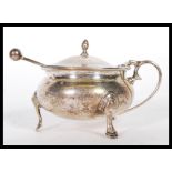 A silver hallmarked lidded mustard pot of bulbous form raised on the cabriole feet having a hinged