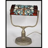 A good 20th century brass bankers desk lamp raised on a round base with a leaded and stained glass