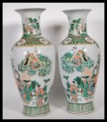 A matching pair of 20th Century Chinese famille rose vases of baluster form, having oriental