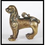 A small early 20th Century Chinese / Tibetan bronze temple dog / fu dog being cast in relief