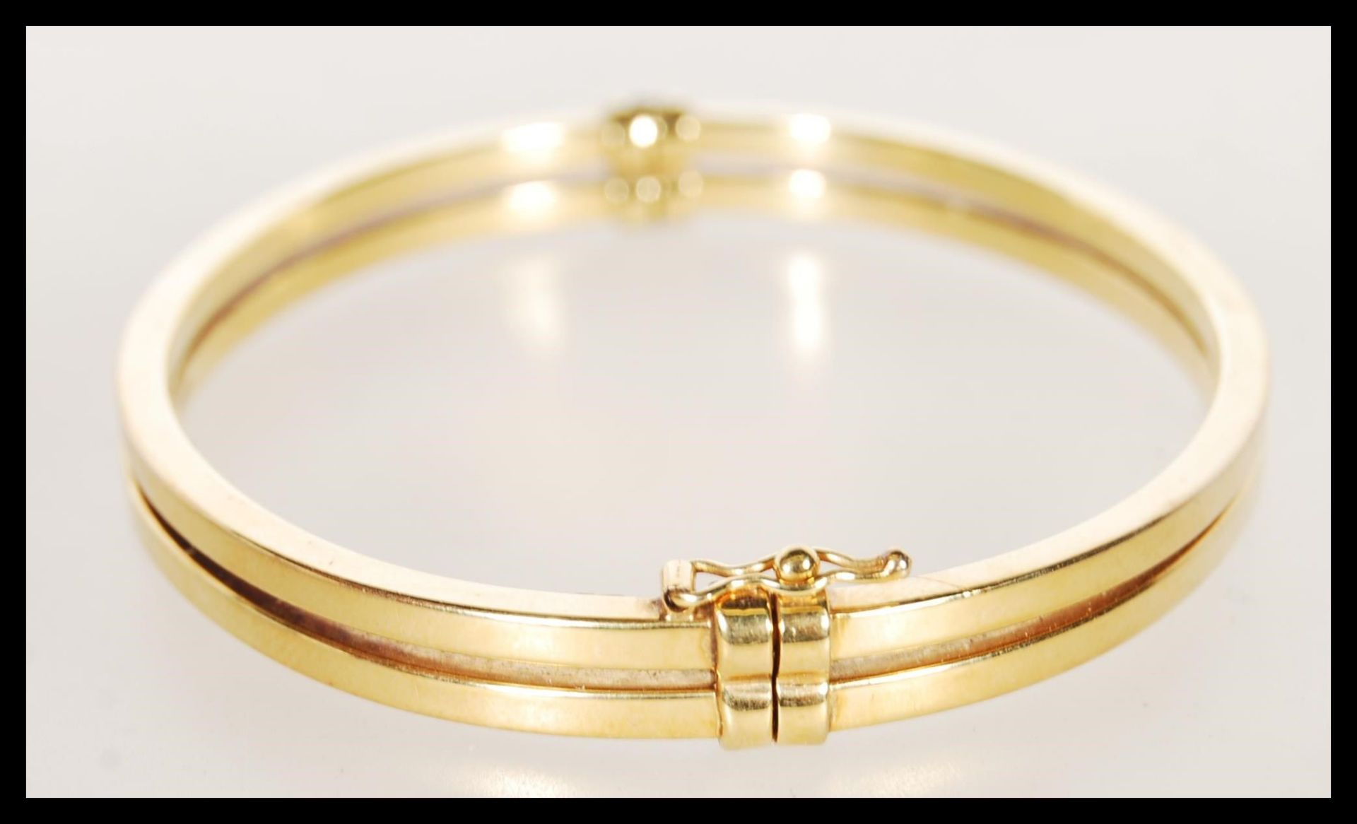 A stamped 9ct gold bangle bracelet having a hinge opening constructed from two bands with a catch to - Bild 2 aus 4