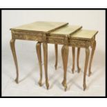 A Louis XVi style gilded nest of three graduating tables of three, shaped supports with faux