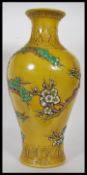 A large 20th century Chinese vase having famille Jaune ground with relief decorated trees by a river
