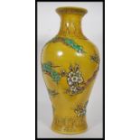 A large 20th century Chinese vase having famille Jaune ground with relief decorated trees by a river