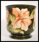 A mid 20th Century Moorcroft tube lined planter on green ground in the Hibiscus pattern. Moorcroft