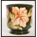 A mid 20th Century Moorcroft tube lined planter on green ground in the Hibiscus pattern. Moorcroft