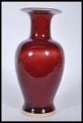 A Chinese vase having red ground and flared rim, being of tapering baluster form. Four character