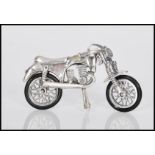 A novelty silver motorcycle being articulated, having rubber tyres with bike stand down. Weighs 13.