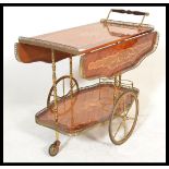 A vintage / retro 20th century Italian floral marquetry effect 2 tier drinks trolley, having brass