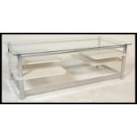 A retro 20th Century circa 1980's glass topped rectangular coffee table raised on chrome supports