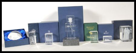 A collection of seven boxed crystal paperweights, each modelled with famous landmarks and symbols of