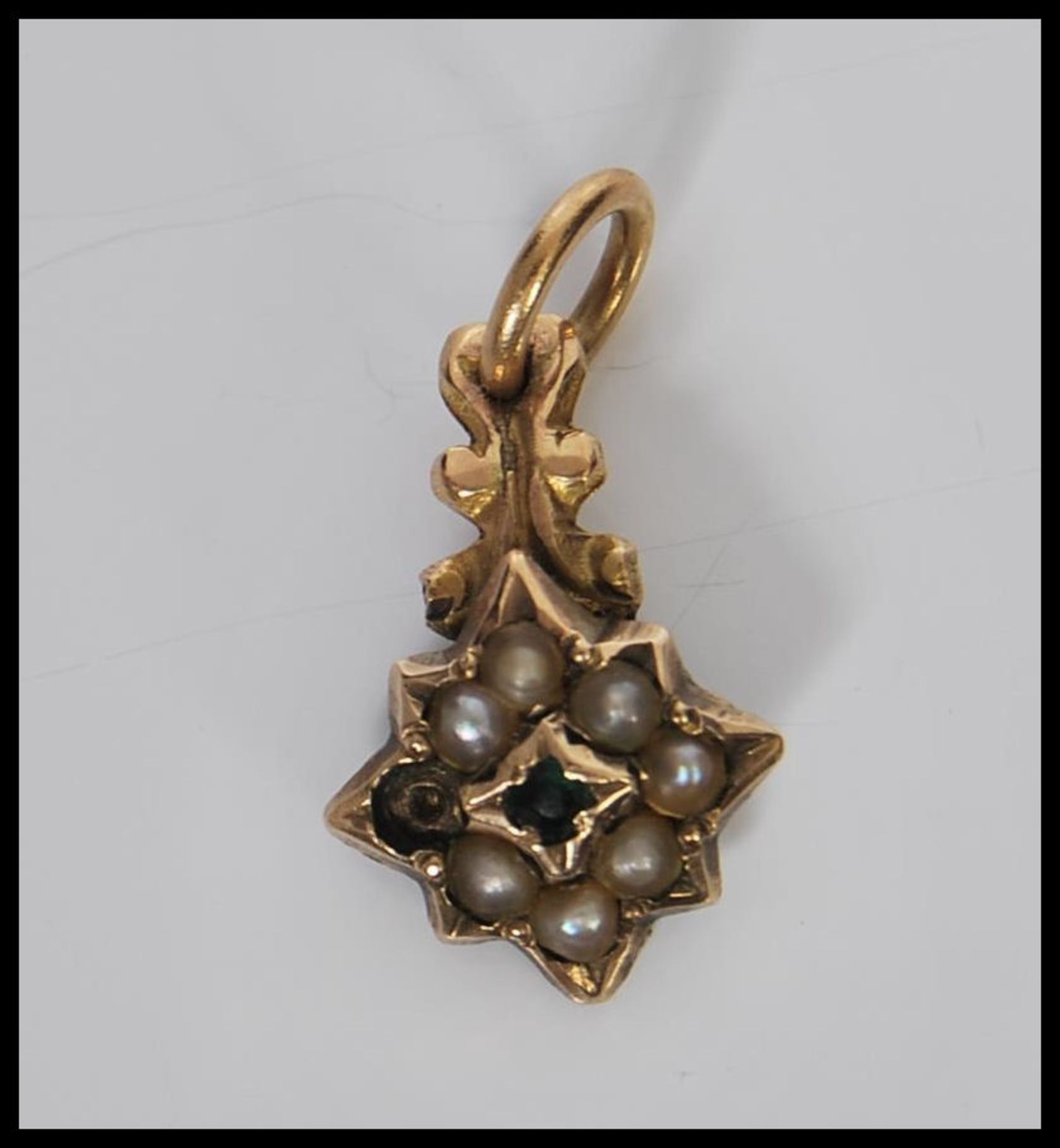 A 19th Century Georgian gold mourning pendant in the form of a star being set with a central green