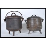 A pair of vintage 20th Century cast iron pot bellied cauldrons with lids, the pots used for the