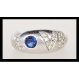 A hallmarked 9ct white gold ring having white accent stones spelling 'Love' with a central blue