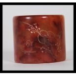 A early 20th Century Chinese large mottled dark red jade archer's thumb ring of cylindrical form.