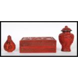 Three Chinese red cinnabar lacquer items to include, snuff bottle and stopper decorated with