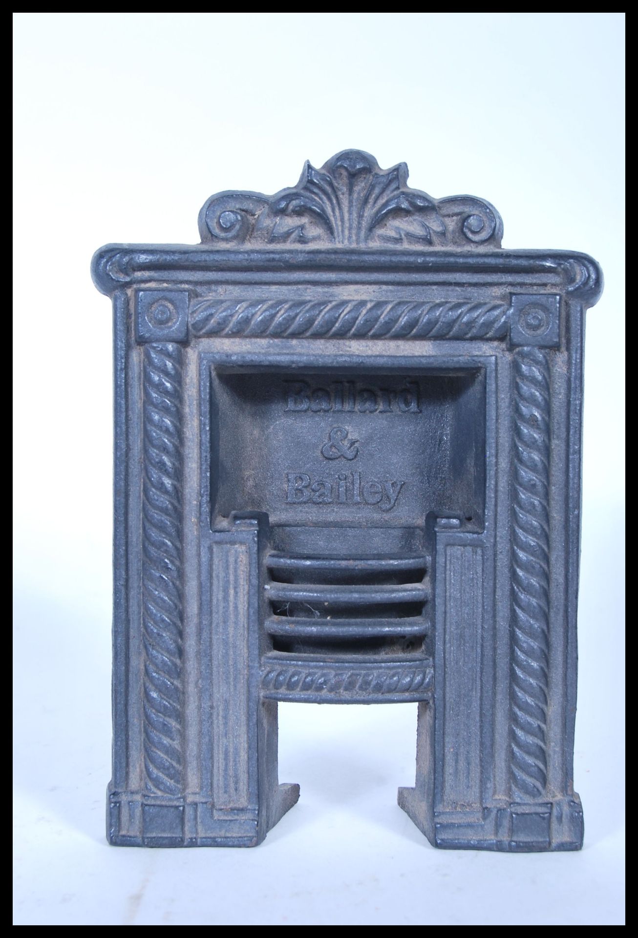 An early 20th Century salesman advertising example of a miniature cast iron fire surround by Ballard