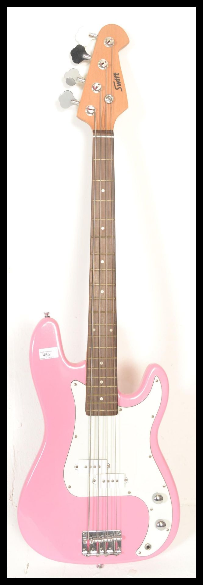 A four string electric bass guitar by swift having a hot pink sprayed body with white scratch guard.