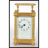 A 20th Century brass carriage clock having four glass panelled sides exposing the mechanism to the