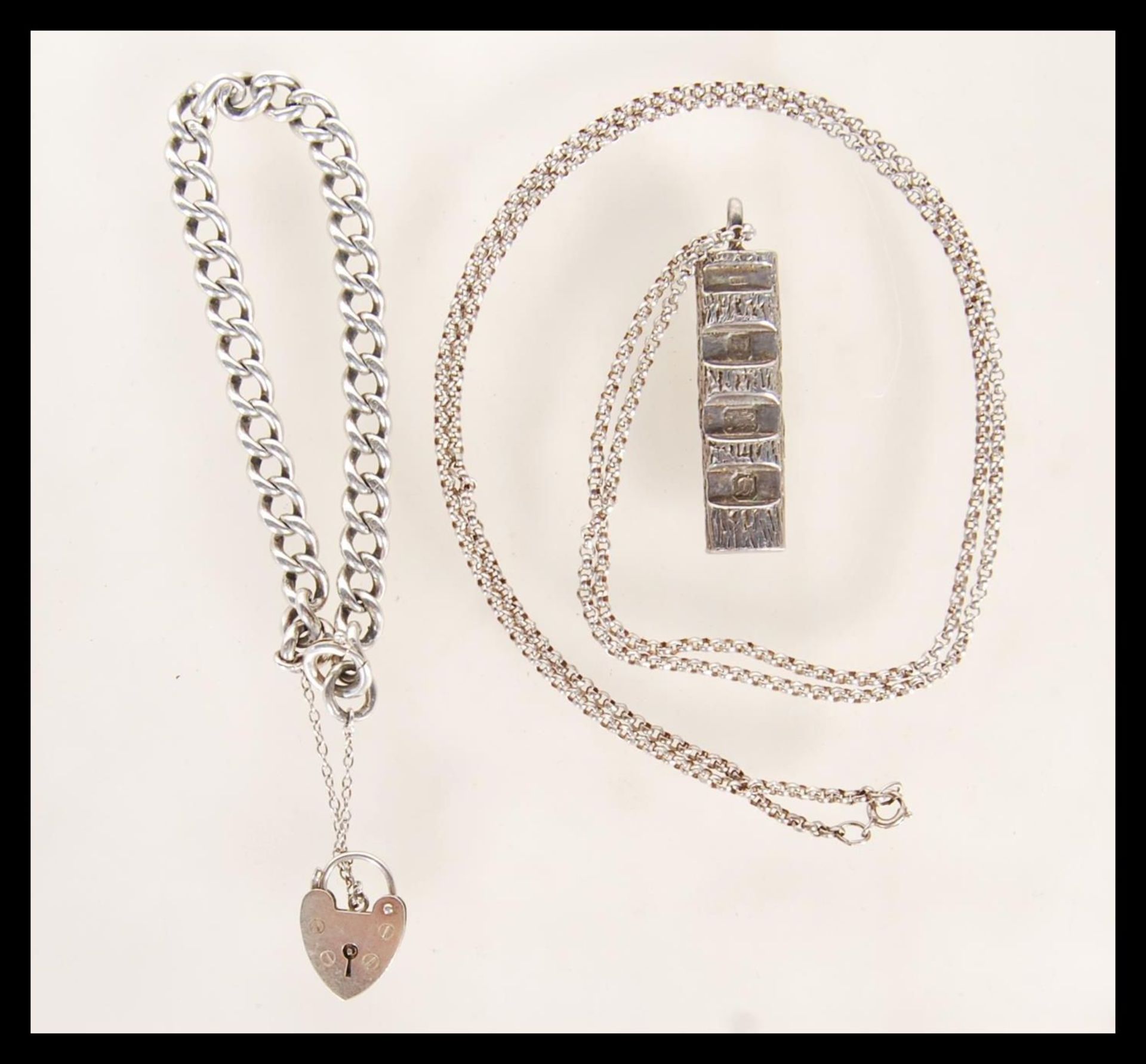 A hallmarked silver ingot pendant on a stamped sterling silver chain, hallmarked London 1978,