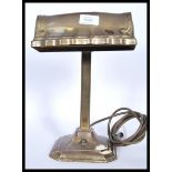 A good 20th century brass bankers desk lamp raised on a terraced square base and brass shade atop.