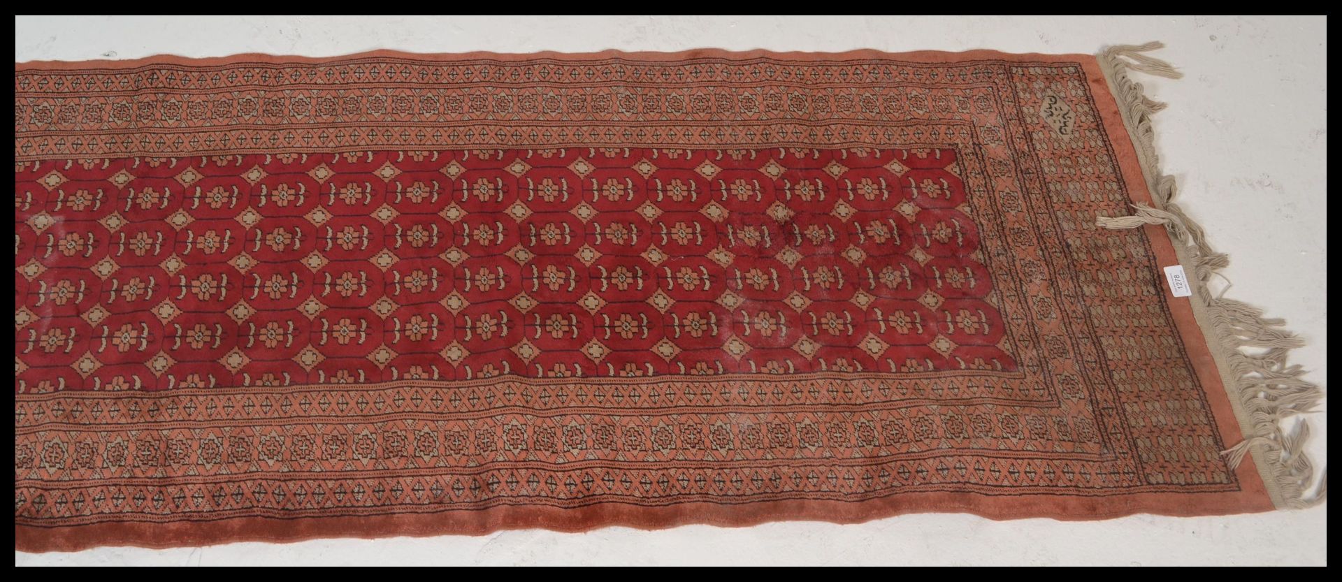 A vintage woolen Persian / Islamic floor rug runner set  on red ground,central panel with - Image 2 of 5