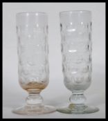 A pair of Georgian drinking glasses having cylindrical bowls with round facets, having pedestal