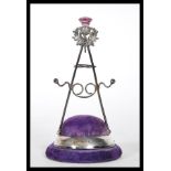 A silver hallmarked Britton, Gould & Co hat pin stand having a purple velvet cushion base with a